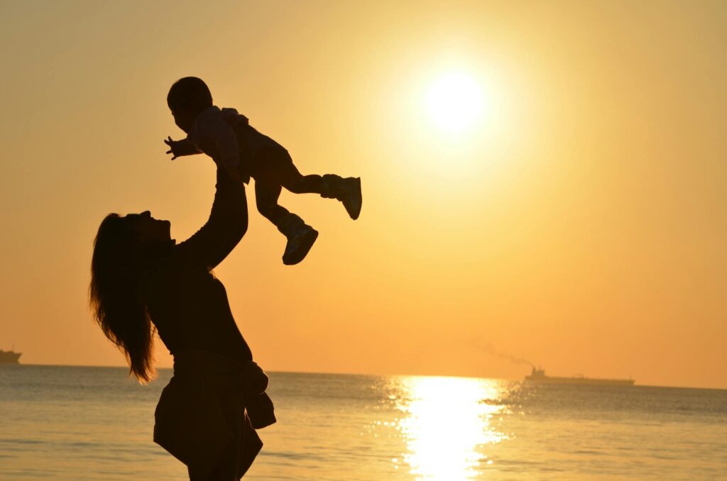Woman holding a child in the sunset