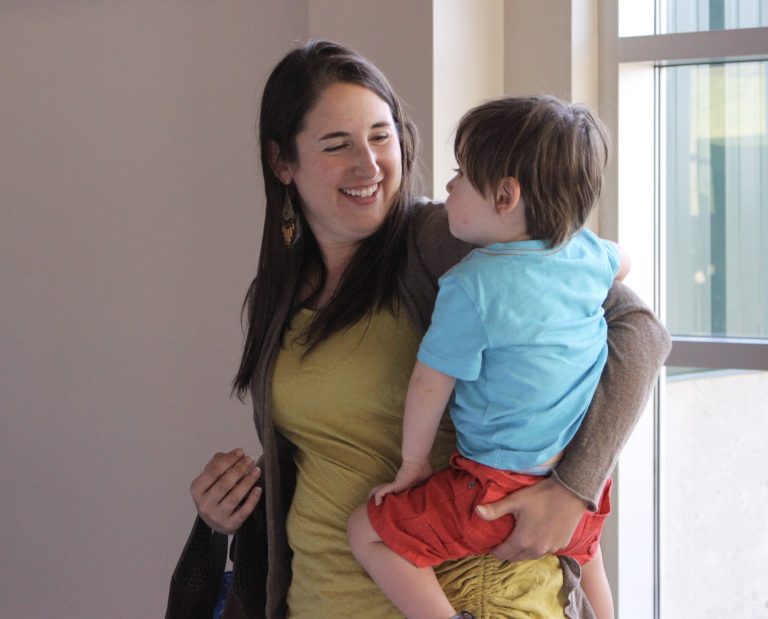 Woman holding a toddler and smiling at him